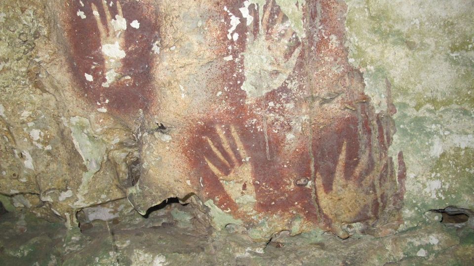 Umrisse einer Hand in einer Höhle auf Sulawesi mit nachträglich verschmälerten Fingern