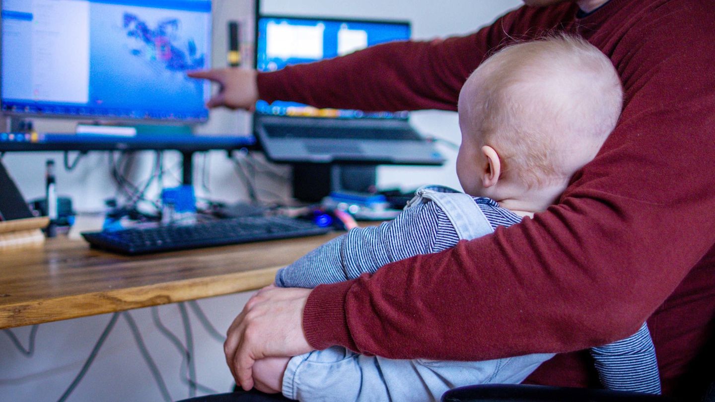 Sicher nicht ganz einfach: Ein junger Vater arbeitet im Homeoffice mit seinem Sohn. (Symbolbild) Foto: Jens Büttner/dpa