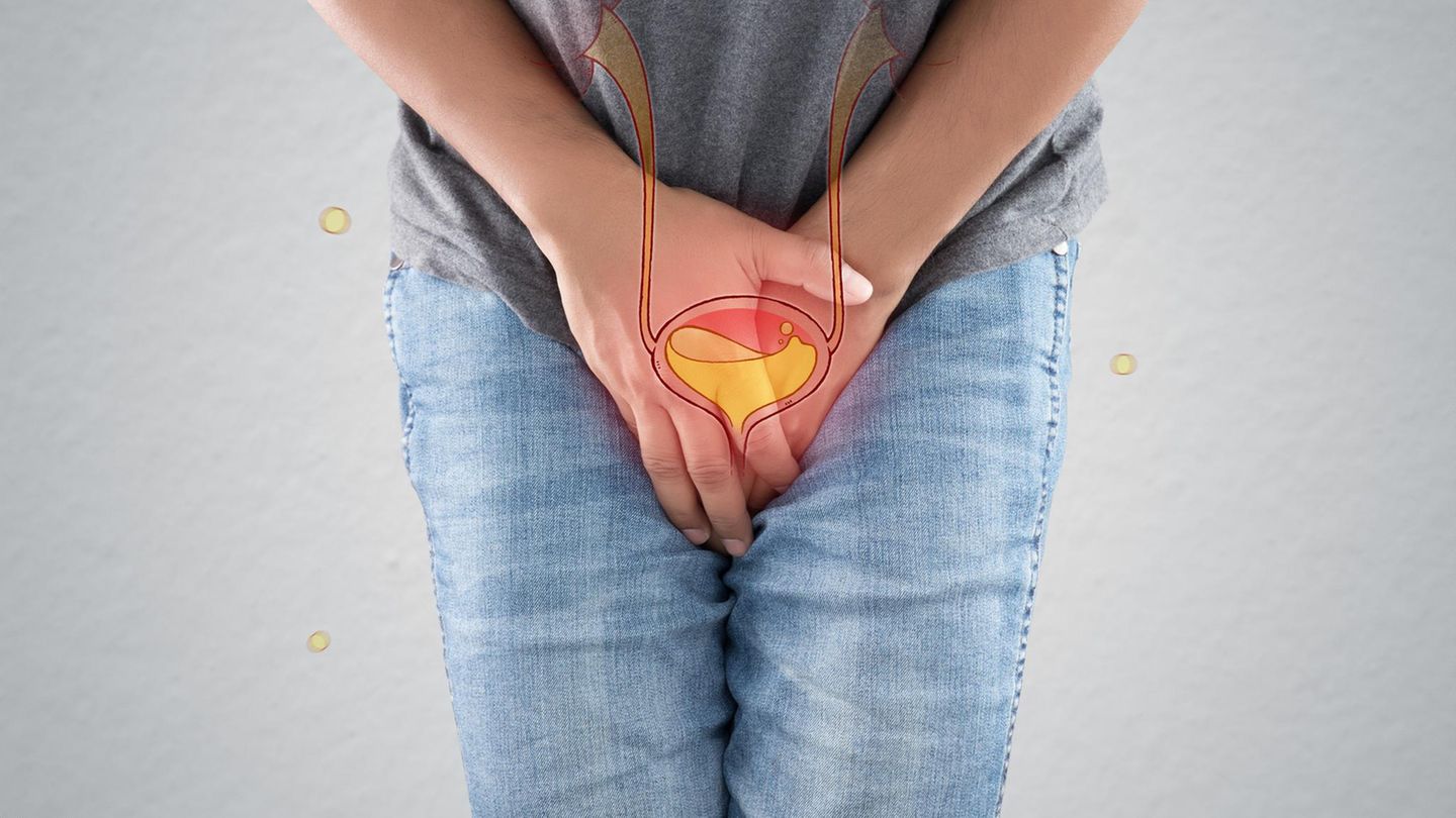 Ein Mann fasst sich verkrampft in den Schritt