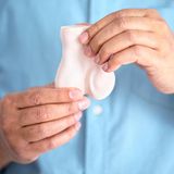 Ein Mann hält das Modell eines Hoden in der Hand