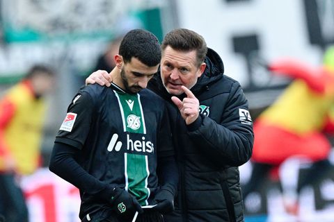 Trainer Christian Titz (r, Hannover 96) spricht bei der Einwechslung mit Waniss Taïbi (Hannover 96). Foto: Uwe Anspach/dpa