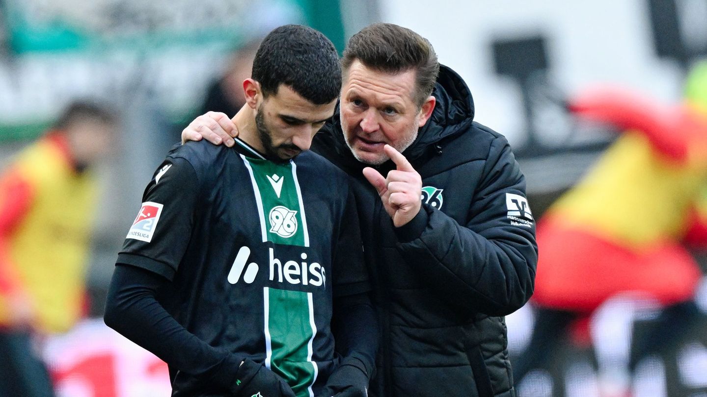 Trainer Christian Titz (r, Hannover 96) spricht bei der Einwechslung mit Waniss Taïbi (Hannover 96). Foto: Uwe Anspach/dpa