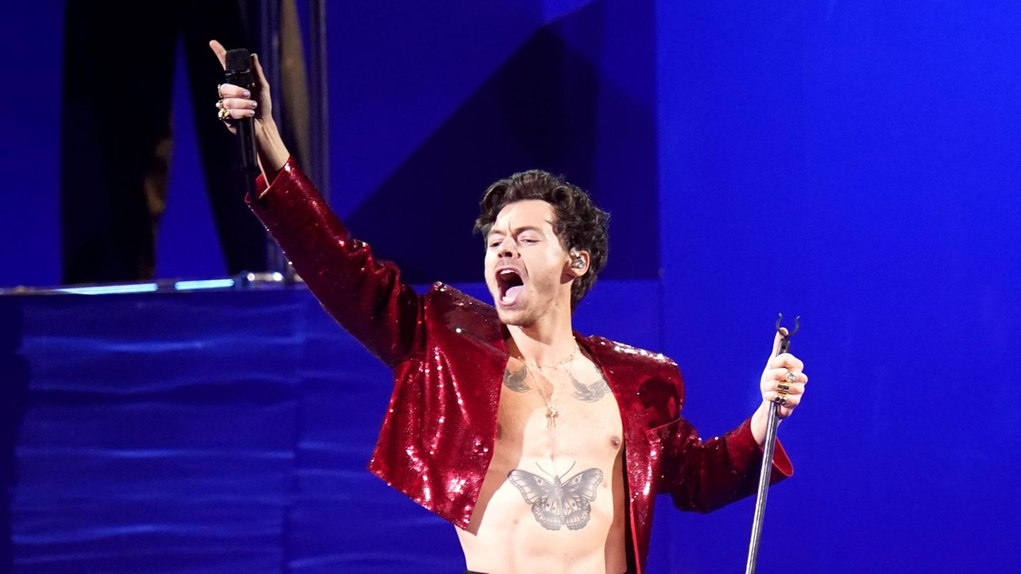 Harry Styles steht bei einem Konzert auf der Bühne und singt
