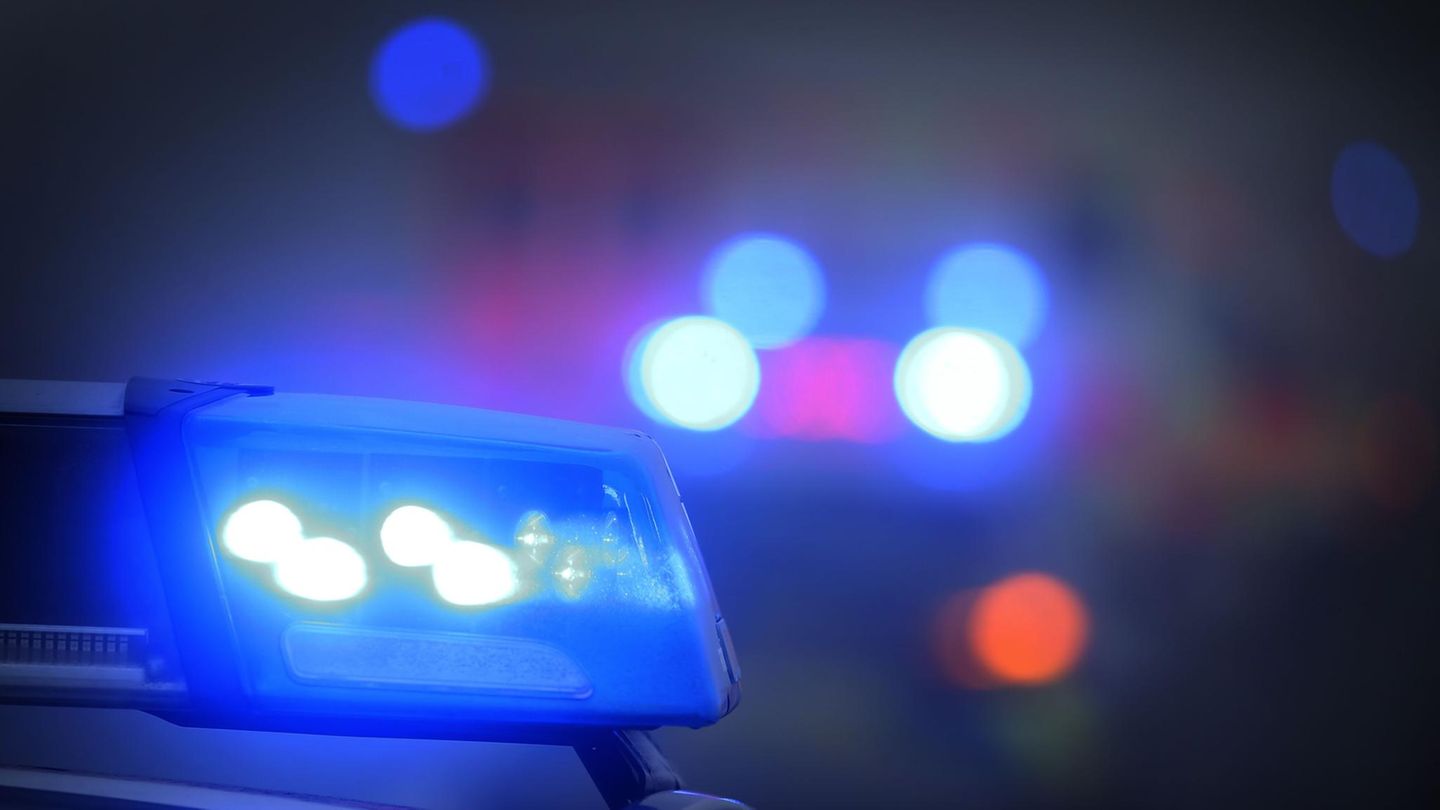 Ein Polizeiauto mit eingeschaltetem Blaulicht steht an einer Unfallstelle