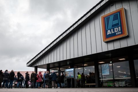 Menschen stehen vor einer Filiale des Discounters Aldi Süd in Nordrhein-Westfalen Schlange