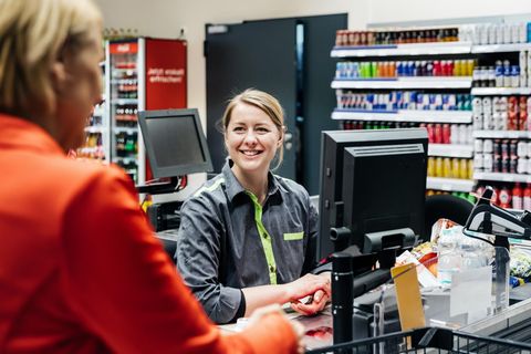 Kassensituation mit Kassiererin und Kundin im Supermarkt
