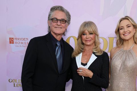 Kate Hudson strahlt bei einer Gala neben Goldie Hawn und Kurt Russell.