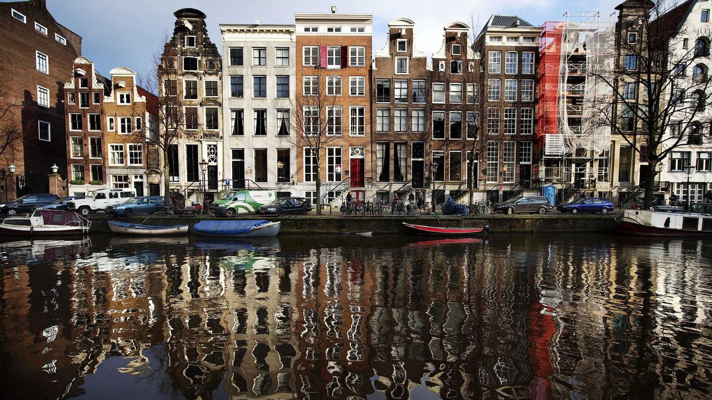 Häuser an der Herengracht spiegeln sich im Wasser in Amsterdam