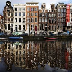 Häuser an der Herengracht spiegeln sich im Wasser in Amsterdam