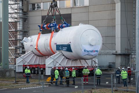 Ein Dampferzeuger wird mithilfe eines Schwerlastkrans aus dem Reaktorgebäude gehoben und auf zwei Träger für den Weitertransport