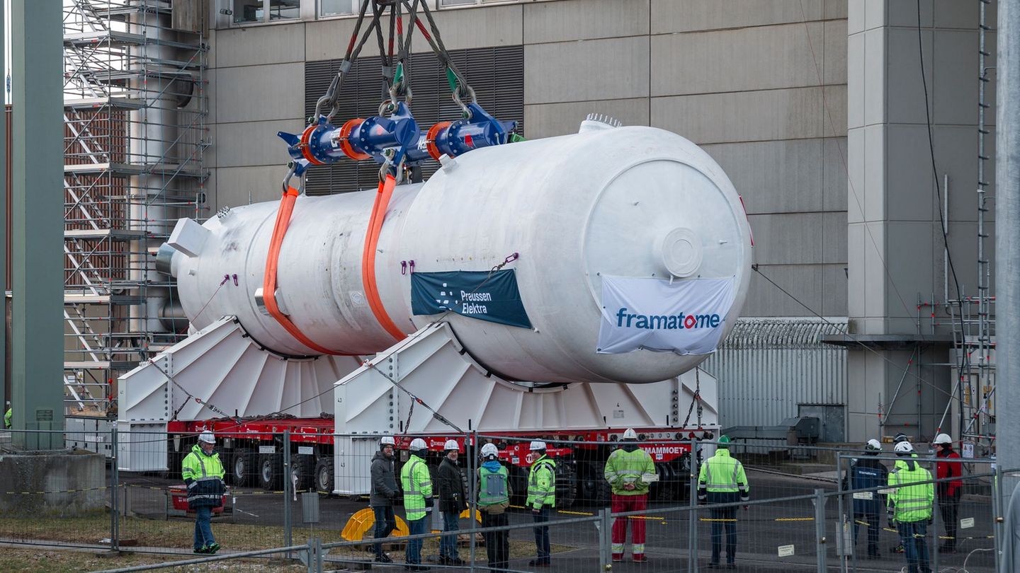 Ein Dampferzeuger wird mithilfe eines Schwerlastkrans aus dem Reaktorgebäude gehoben und auf zwei Träger für den Weitertransport