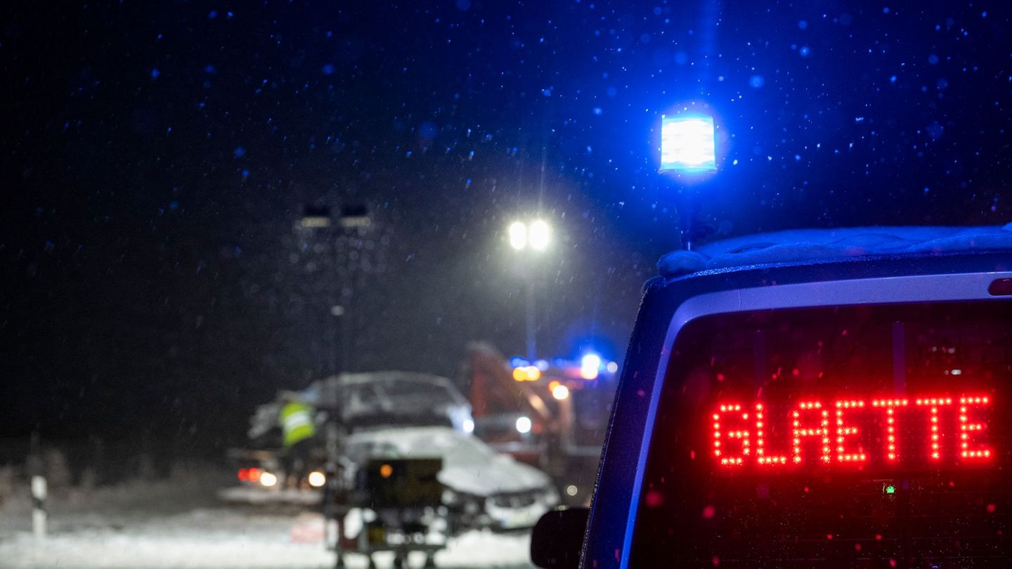 Auf der verschneiten Bundesstraße 12 warnt an einer Unfallstelle ein Polizeifahrzeug vor Glätte. Foto: Stefan Puchner/dpa