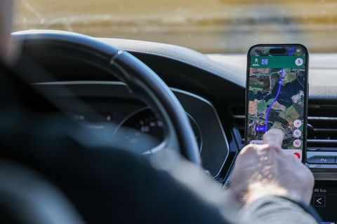 So ist es derzeit erlaubt: Das Handy steckt in der Halterung und wird nur kurz vom Fahrer beachtet. (Symbolbild) Foto: Jan Woita