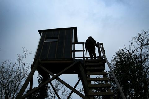 Jägerin auf einem Hochsitz