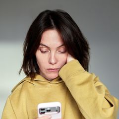 Handynacken: Frau blickt auf Handy