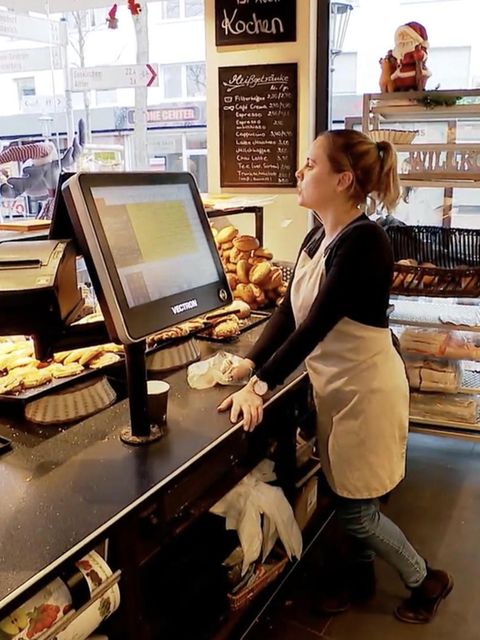 Eine Bäckereifachverkäuferin redet mit einer Frau.