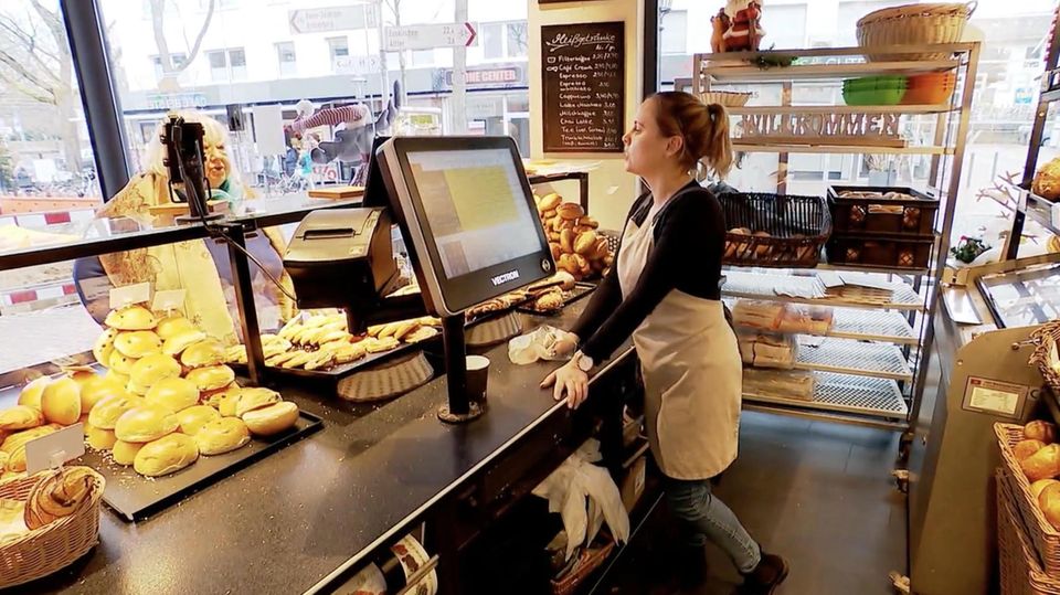 Eine Bäckereifachverkäuferin redet mit einer Frau.
