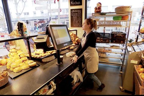 Eine Bäckereifachverkäuferin redet mit einer Frau.