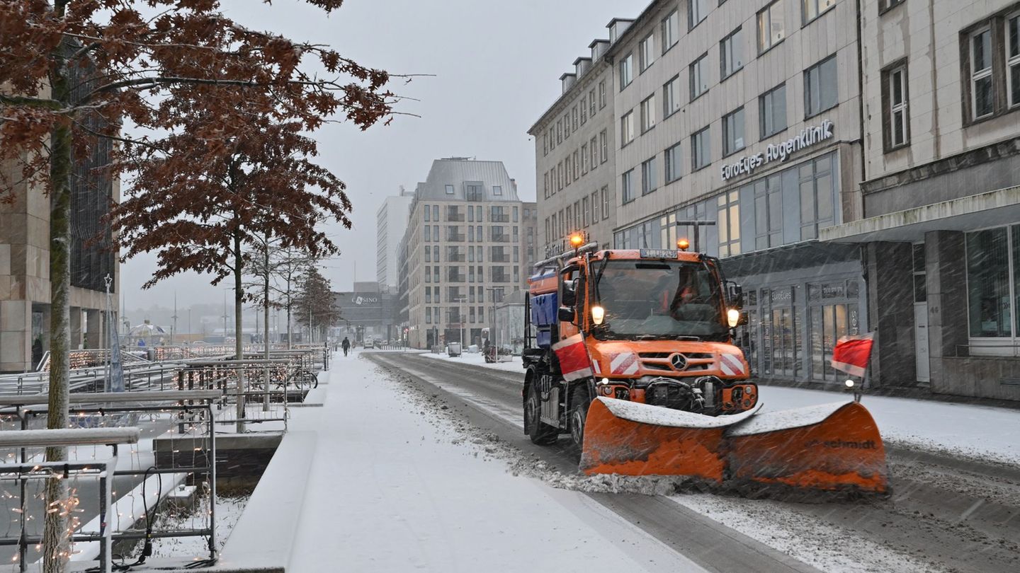 Am Holstenfleet in Kiel räumt ein Unimog den Schneematsch an die Seite. Foto: Felix Müschen/dpa