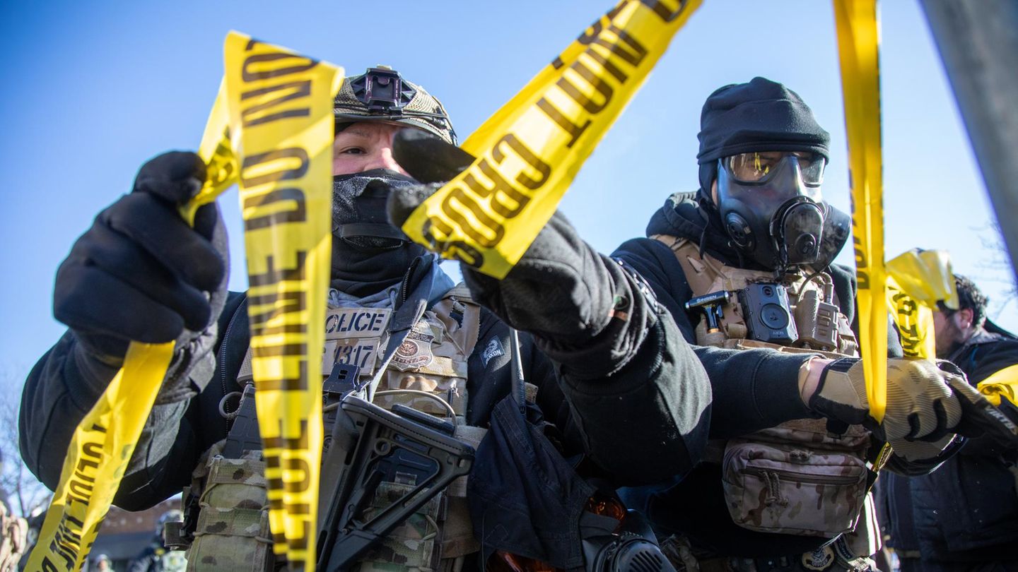 ICE Agenten reißen gelbes Flatterband ein