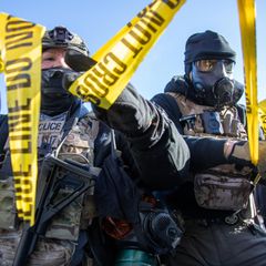 ICE Agenten reißen gelbes Flatterband ein