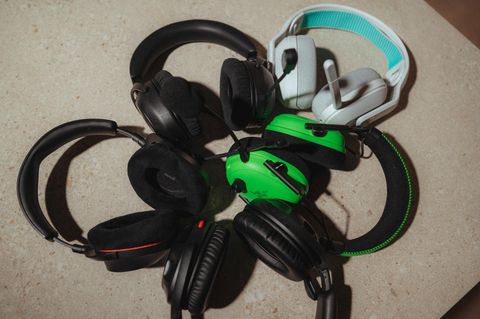 Fünf Gaming-Headsets hängen über einen Bildschirm