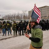 Ein Demonstrant zeigt vor dem ICE-Hauptquartier in Minneapolis die umgedrehte US-Nationalflagge – ein Symbol des Protests. Es bedeutet: Das Land befindet sich in höchster Not