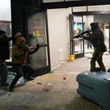 Dennoch gehen die Razzien weiter. Ein ICE Beamter richtet eine Waffe auf einen mutmaßlichen Migranten