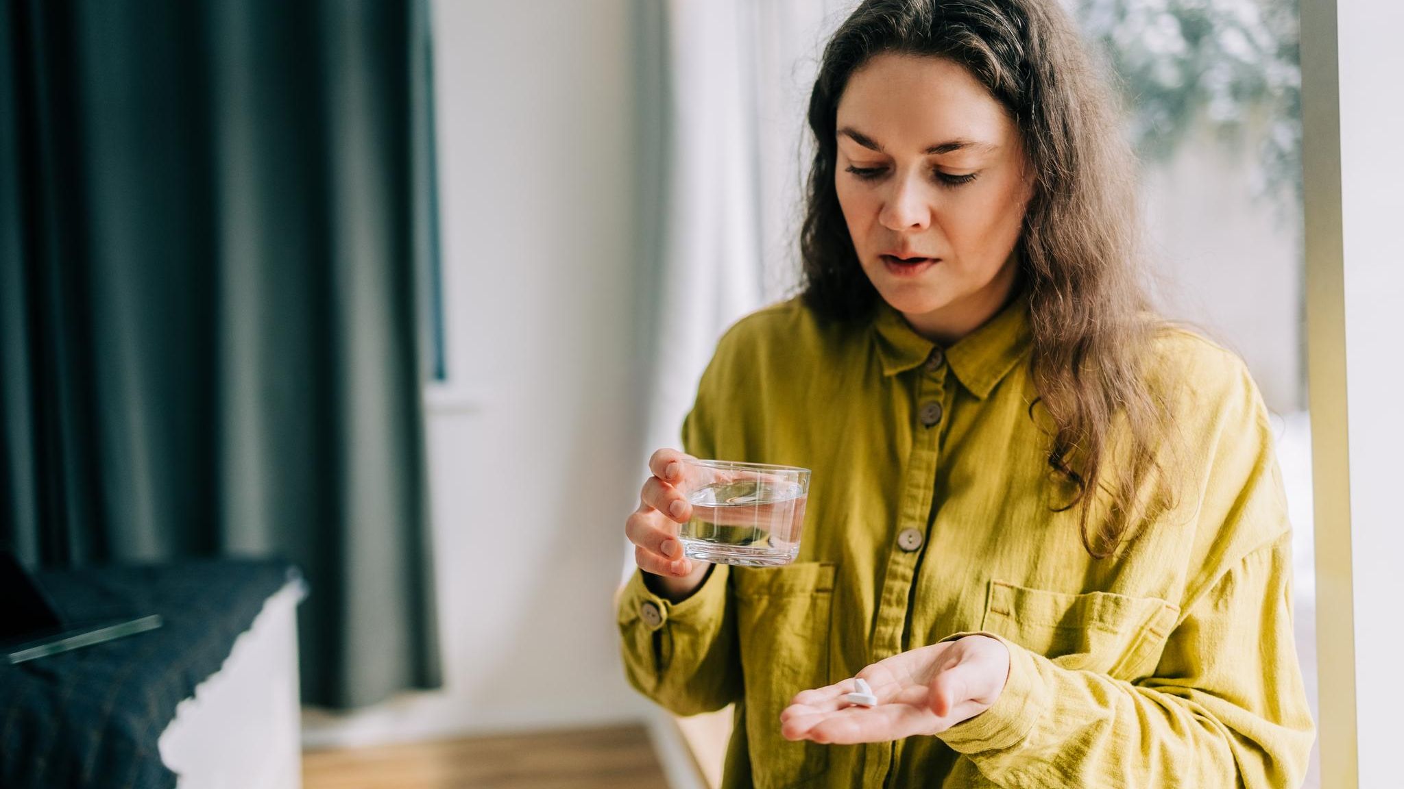 Eine Frau hält einige Tabletten in der Hand