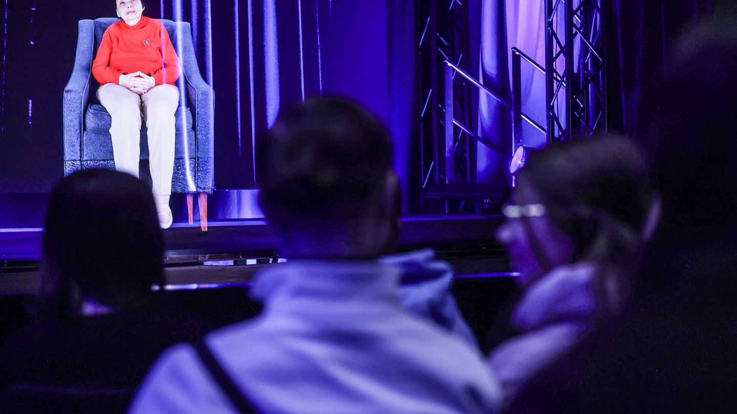 Man könnte glaube, Inge Auerbacher säße tatsächlich auf der Bühne. Dabei ist es nur ein dreidimensionales Lichtbild von ihr, das