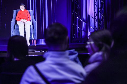 Man könnte glaube, Inge Auerbacher säße tatsächlich auf der Bühne. Dabei ist es nur ein dreidimensionales Lichtbild von ihr, das