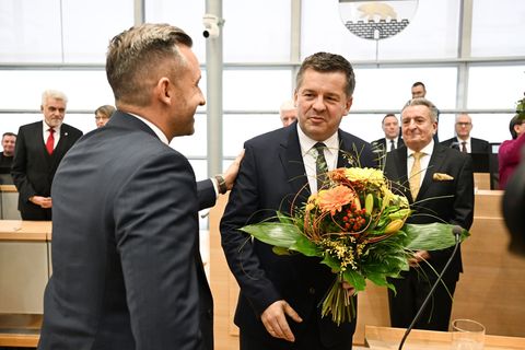 Sven Schulze bekommt Glückwünsche und einen Blumenstrauß vom AfD-Spitzenkandidaten Ulrich Siegmund. Foto: Hendrik Schmidt/dpa