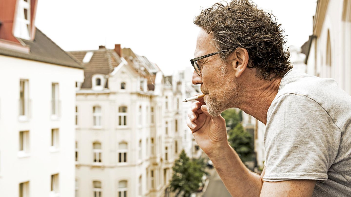 Mann steht auf dem Balkon und raucht, als Untermieter dürfte er nicht benachteiligt werden