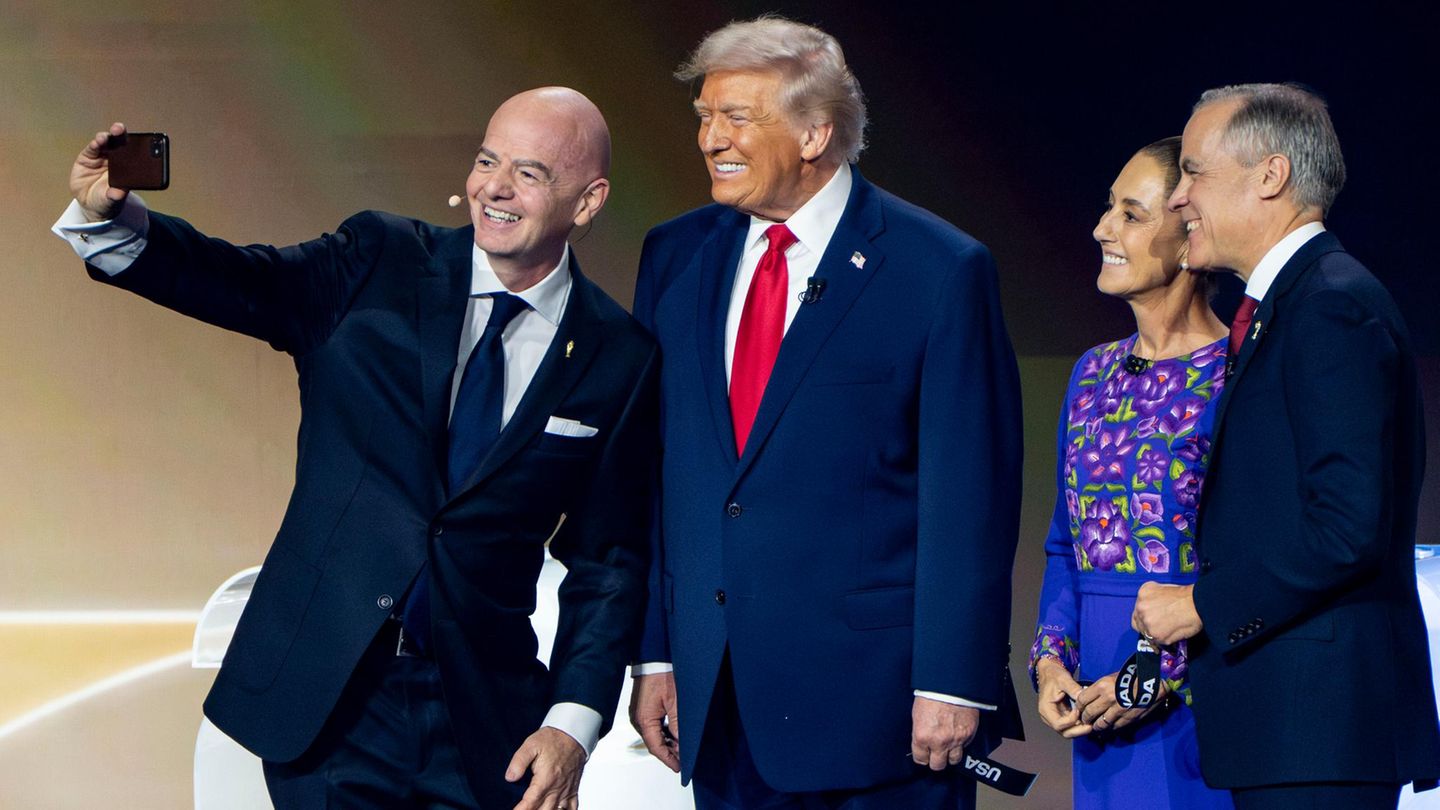 Fifa-Präsident Gianni Infantino, US-Präsident Donald Trump, die mexikanische Präsidentin Claudia Sheinbaum und Kanadas Premierminister Mike Carney grinsen bei der WM-Auslosung in die Kamera. Angesichts der aggressiven Außen- wie Innenpolitik Trumps denken einige in Deutschland über einen WM-Boykott nach. Die Deutsche Presse-Agentur spricht von einer "Scheindebatte". DFB und DFL wiegeln ab, und ein breiterer, gesellschaftlicher Konsens wie bei der Debatte vor vier Jahren scheint bislang nicht zu existieren