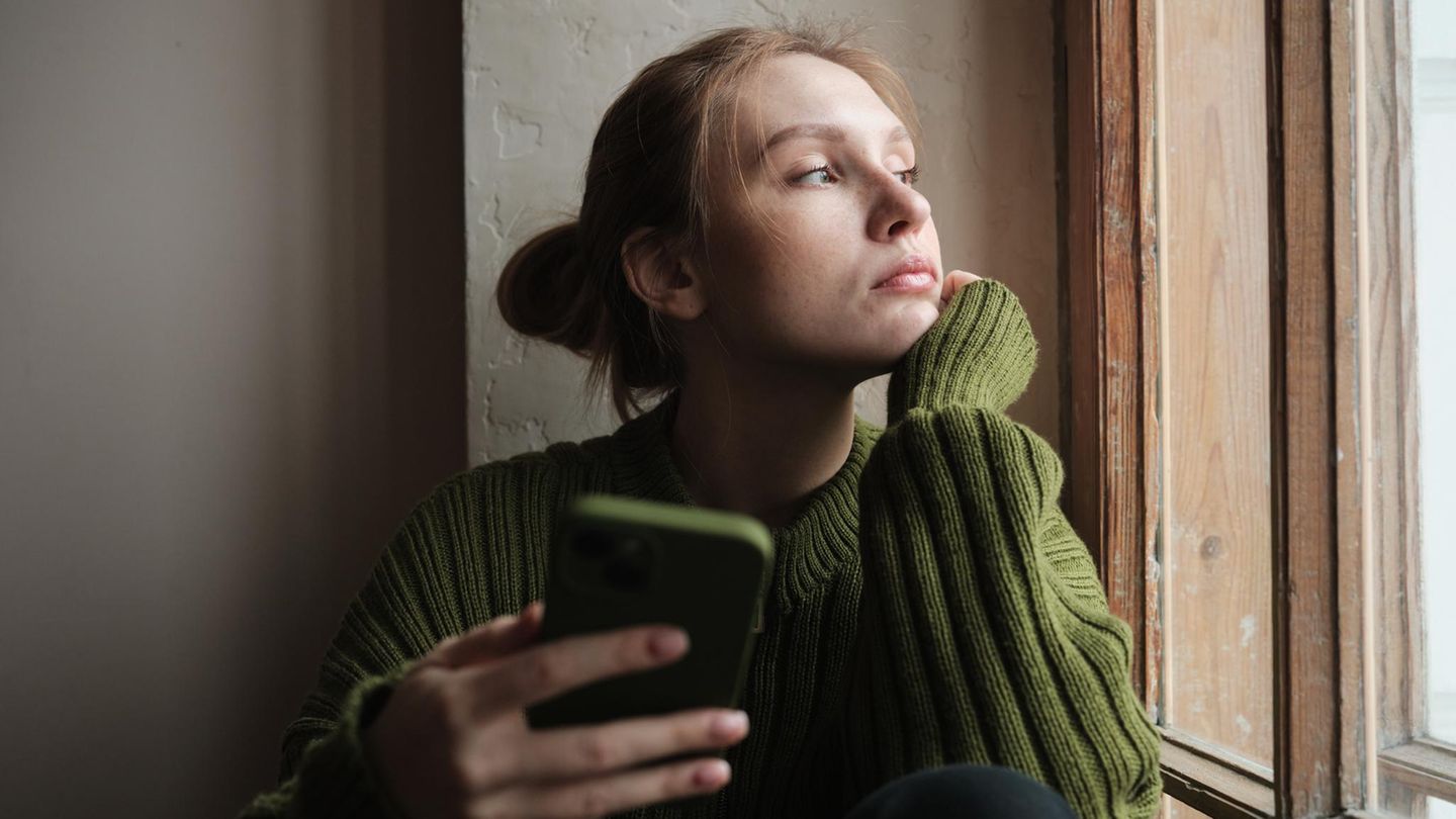 Resilienz: eine junge Frau blickt traurit aus dem Fenster
