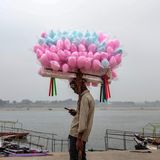 Varanasi, Indien. Einerseits sieht es aus, als trüge der junge Mann eine große Last auf dem Kopf – bis einem einfällt: Zuckerwatte ist nicht besonders schwer. Zumindest kann der Verkäufer relativ entspannt etwas auf seinem Handy machen. Und trotzdem: Ohne Kundschaft ist auch dieser Job kein Zuckerschlecken
