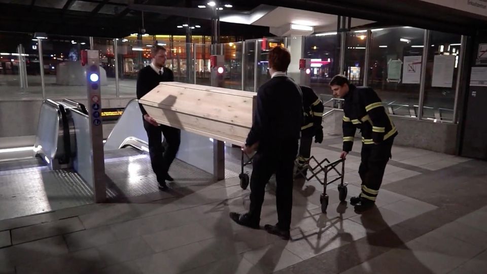 Sarg wird aus U-Bahnstation hoch getragen