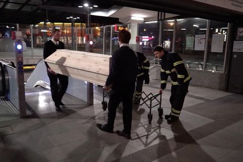 Sarg wird aus U-Bahnstation hoch getragen
