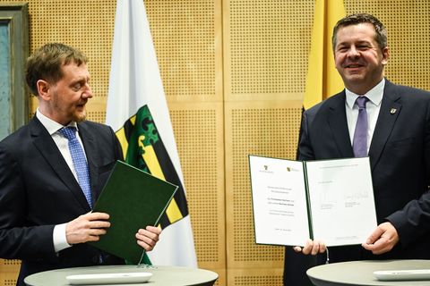 Die Regierungschefs von Sachsen und Sachsen-Anhalt unterzeichnen eine Erklärung für die Flughäfen. Foto: Britta Pedersen/dpa