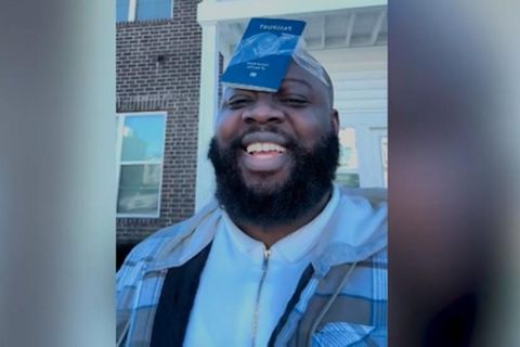 Mann klebt sich seinen Reisepass an die Stirn