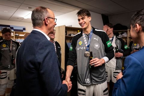 Bundeskanzler Friedrich Merz gratuliert Deutschlands Handballern in der Kabine. Foto: Guido Bergmann/Presse- und Informationsamt