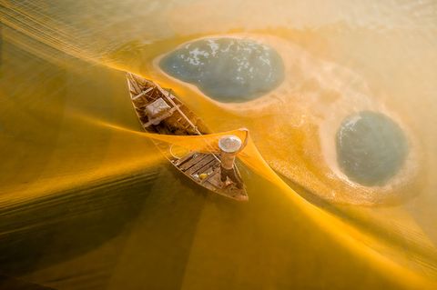 Im Morgenlicht leuchten die Netze golden über einem Fluss in Vietnam. Die Fischer spannen sie für ihren Fang weit übers Wasser. Auf Teo Chin Leongs Foto ist der Fang nicht zu sehen. Die sanften Farben und die klare Komposition lassen die Szene friedlich wirken, fast wie in einem Traum oder einer Fantasie