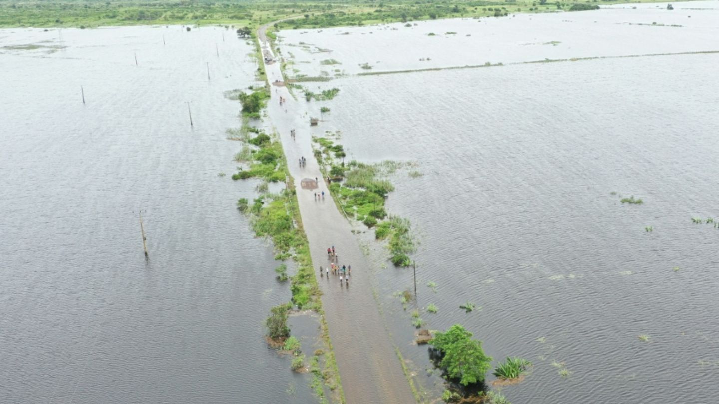 Menschen auf einer überschwemmten Straße nahe Maputo