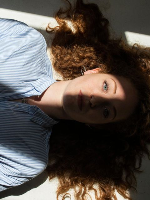 Stress: Eine Frau liegt entspannt auf dem Rücken. Sonne fällt durch ein Fenster auf ihr Gesicht