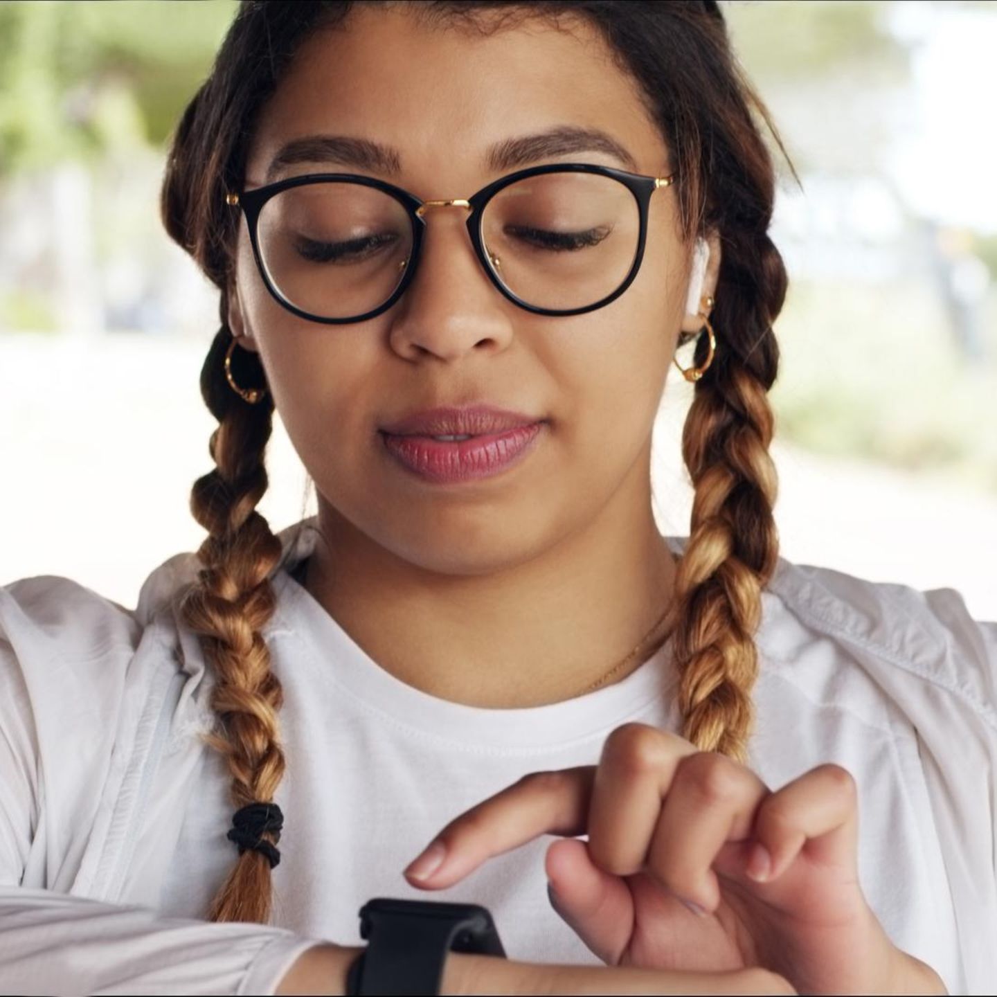 Eine Frau checkt ihre Herzfrequenz auf einer Pulsuhr am Arm