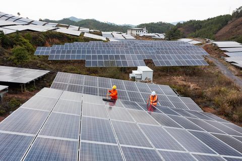 zwei Arbeiter putzen die Solarzellenoberfläche