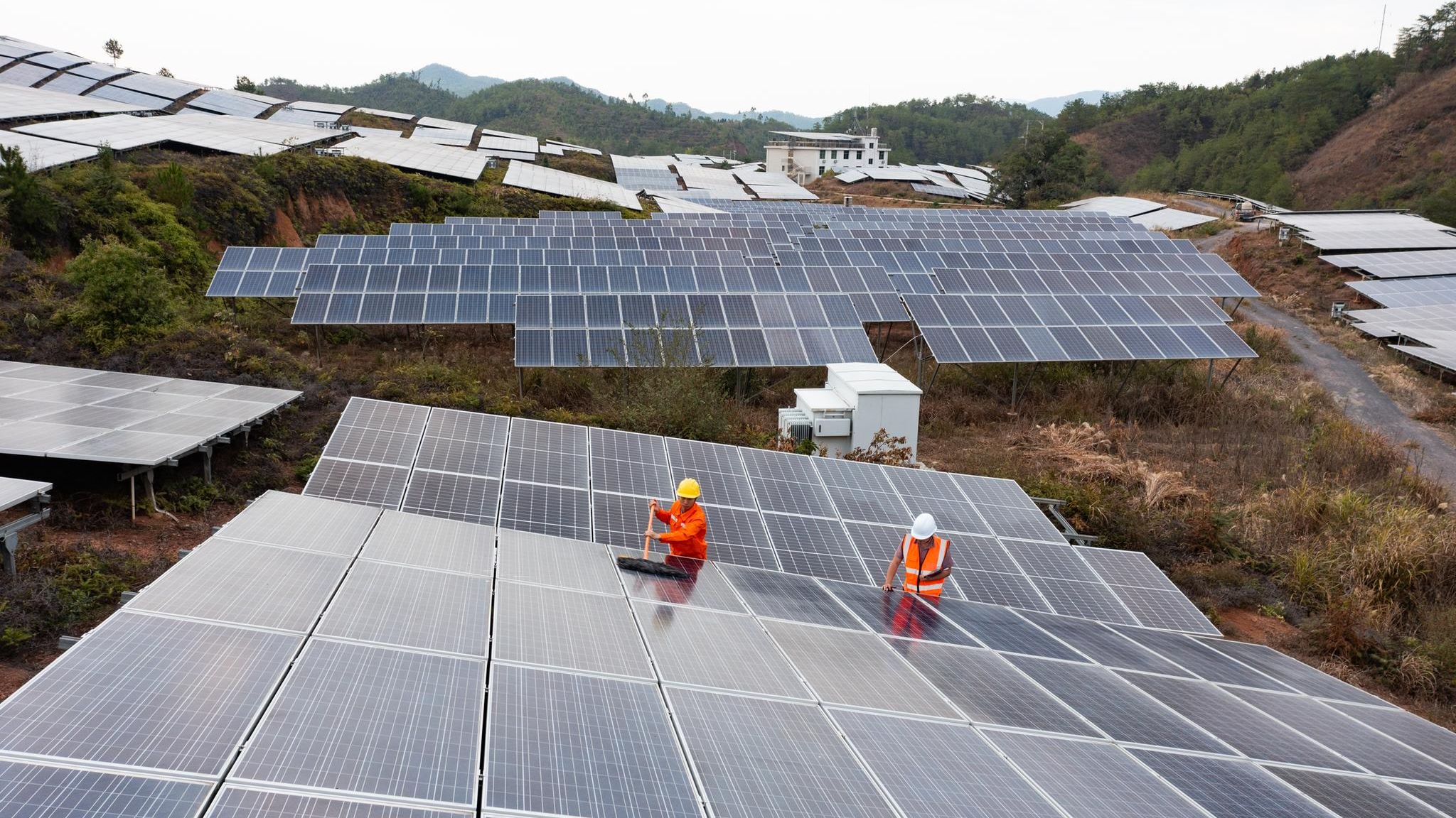 zwei Arbeiter putzen die Solarzellenoberfläche