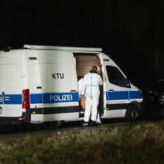 Ein weißer Transporter der Polizei steht am Waldsee in Dormagen, wo ein toter Jugendlicher gefunden wurde