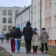 Migranten gehen über das Gelände einer Erstaufnahmeeinrichtung