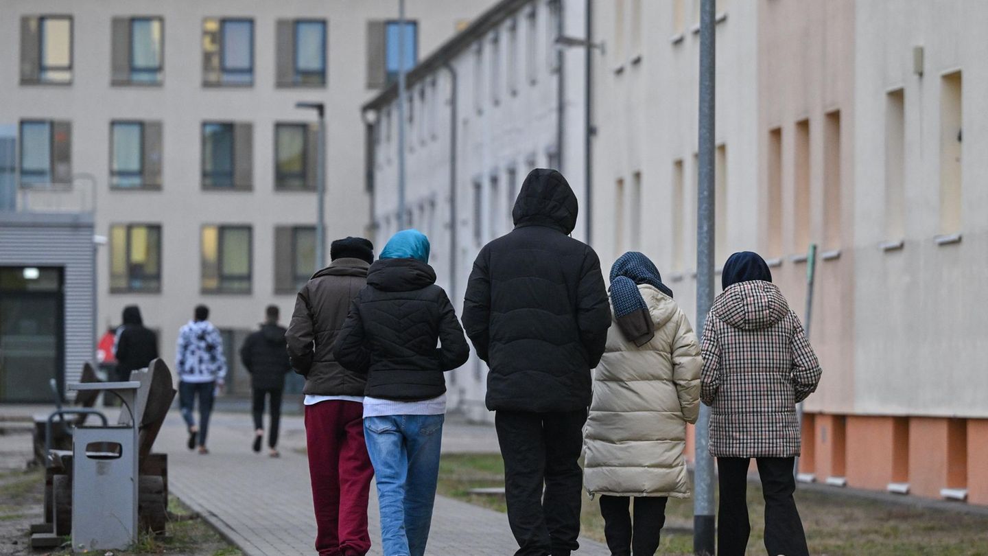 Migranten gehen über das Gelände einer Erstaufnahmeeinrichtung